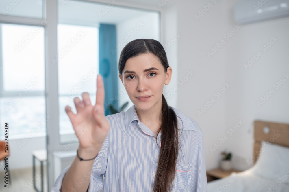 Calm lady pointing up with a forefinger