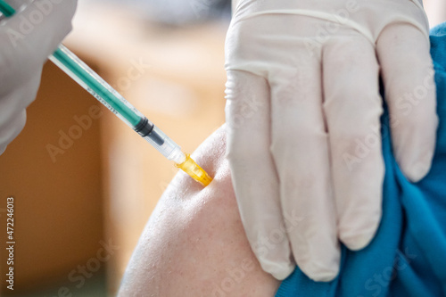 A patient getting a covid19 vaccine injection / A close-up picture of a doctor giving a covid-19 vaccination injection.