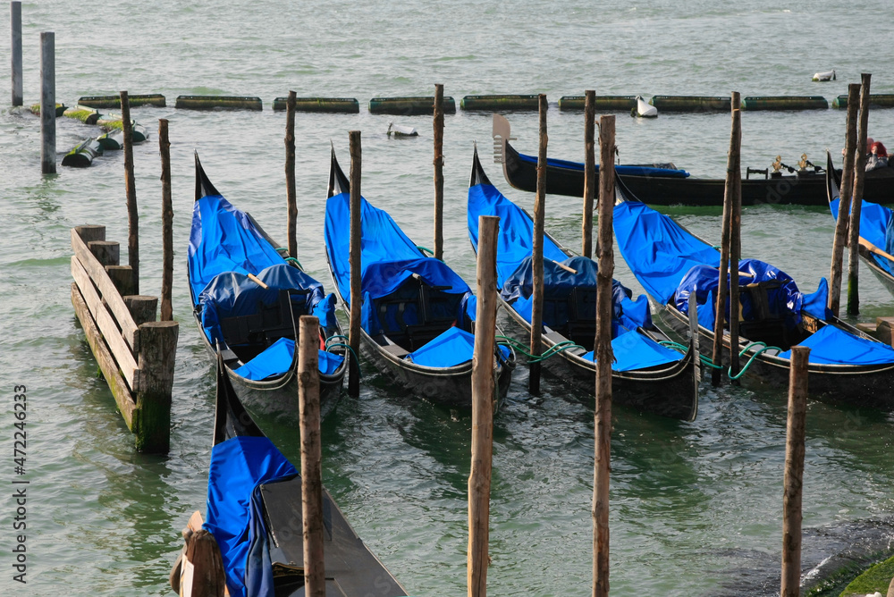 Gondolas docked in a row near the pier Venice, Italy.
