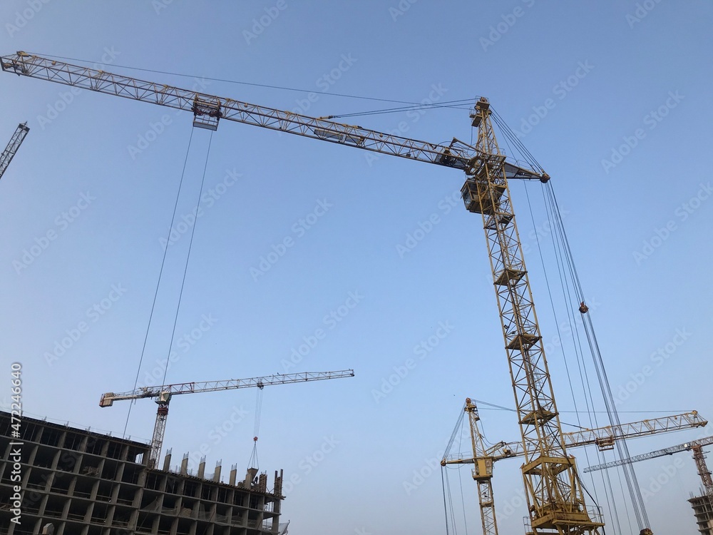 construction crane on a background of blue sky. crane for moving heavy concrete blocks for the construction of houses and high-rise buildings construction crane on a background of blue sky. crane for moving heavy concrete blocks for the construction of houses and high-rise buildings