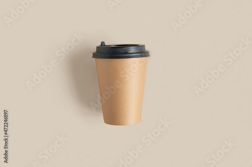 Top view of a Brown coffee paper cup. Mockup with lid. Set of craft paper cups for coffee or tea on beige background. Flat lay. Zero waste, plastic free concept. Disposable Recycled cups