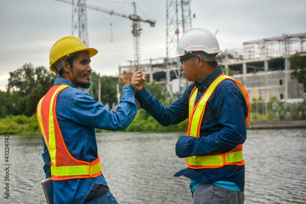 Teamwork Engineer and businessman handshake at construction site Teamwork Engineer and businessman handshake at construction site