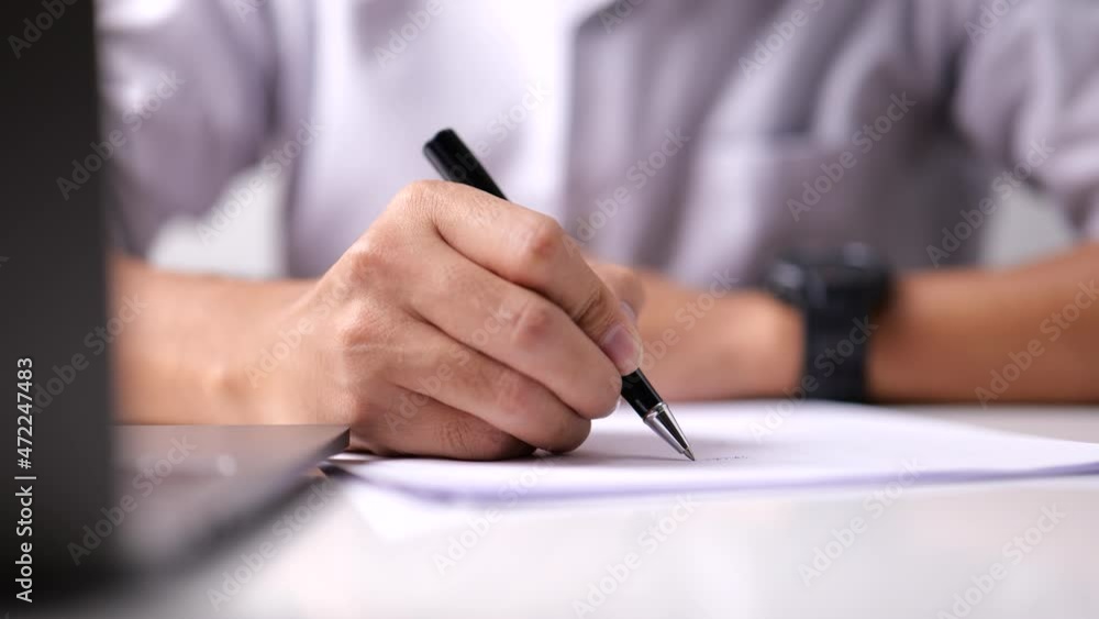 In the office, a businessman signs a document paper. In the office, a businessman signs a document paper.