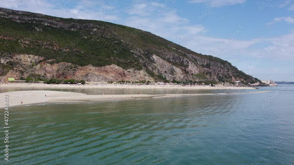 Ocean coast with mountains. Island in Portugal with a sandy beach. Blue ocean and sandy beach. Aerial view of sea spit. Ocean coast with mountains. Island in Portugal with a sandy beach. Blue ocean and sandy beach. Aerial view of sea spit.