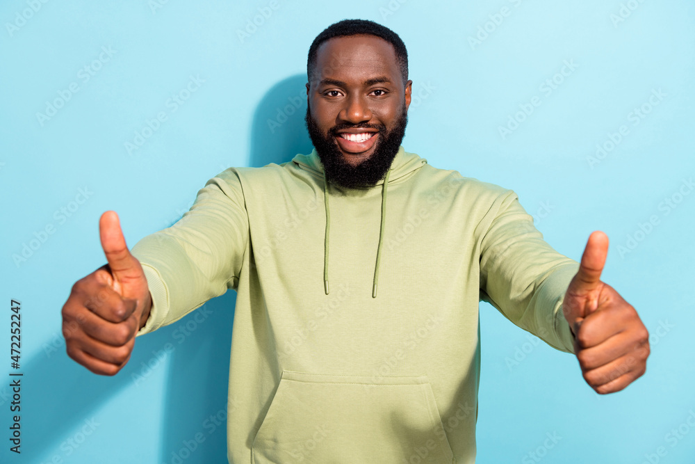 Photo of cheerful glad person two hands show thumb up toothy smile isolated on blue color background Photo of cheerful glad person two hands show thumb up toothy smile isolated on blue color background