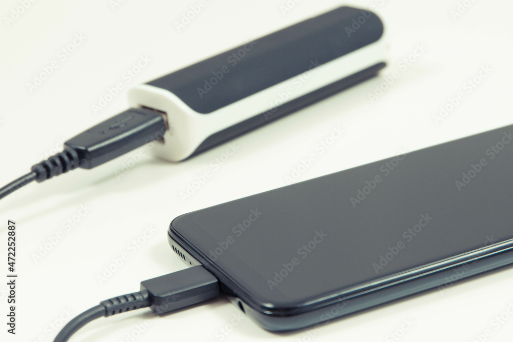 Smartphone with connected plug of powerbank. Telephone charging Smartphone with connected plug of powerbank. Telephone charging