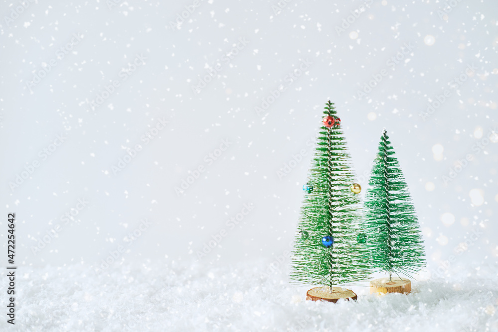 Small Christmas trees on a light background. Toy green trees in a snowdrift. Small Christmas trees on a light background. Toy green trees in a snowdrift.