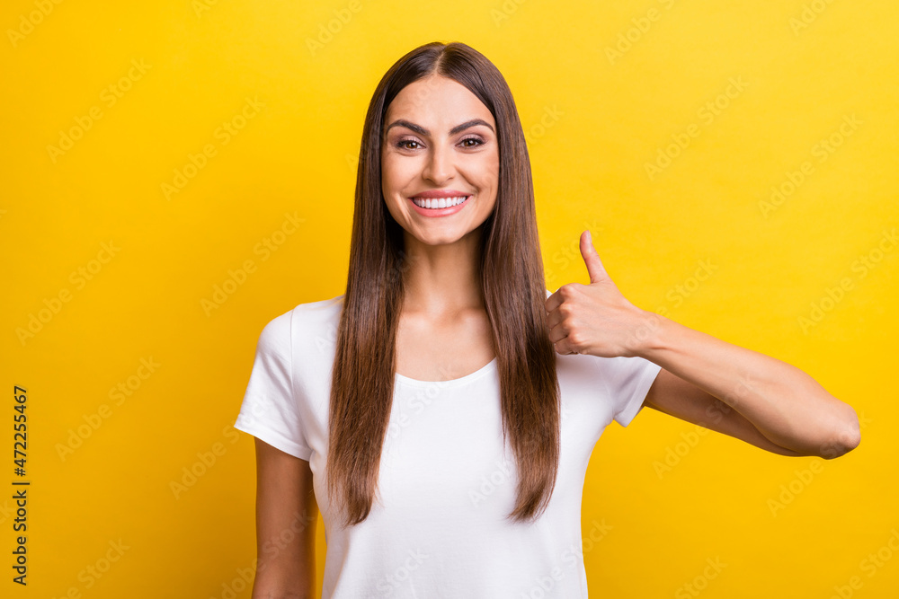 Photo portrait girl brown hair showing thumb-up gesture advising isolated vivid yellow color background Photo portrait girl brown hair showing thumb-up gesture advising isolated vivid yellow color background