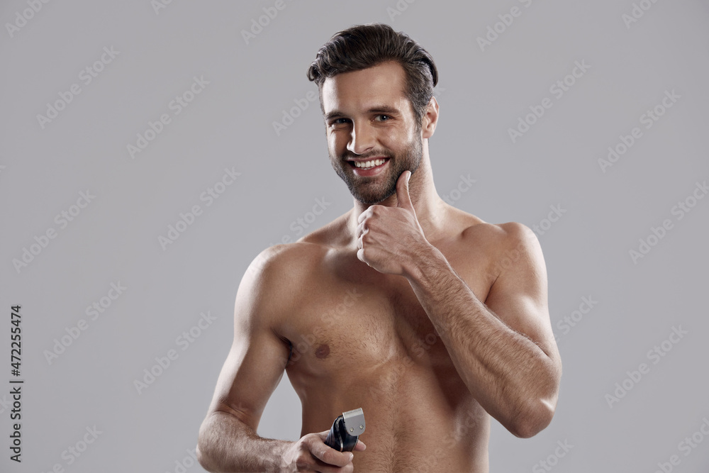 Man hold electric razor and touch his ideal beard Man hold electric razor and touch his ideal beard