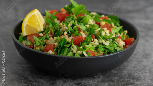 Middle Eastern cuisine. Vegetarian salad with bulgur  vegetables. Fresh bright arabic salad. Tabbouleh salad