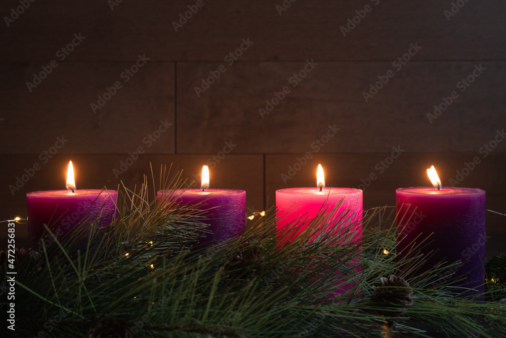 Four candles lit in advent wreath for fourth week of advent with pillar  candles on dark wood Stock Photo | Adobe Stock