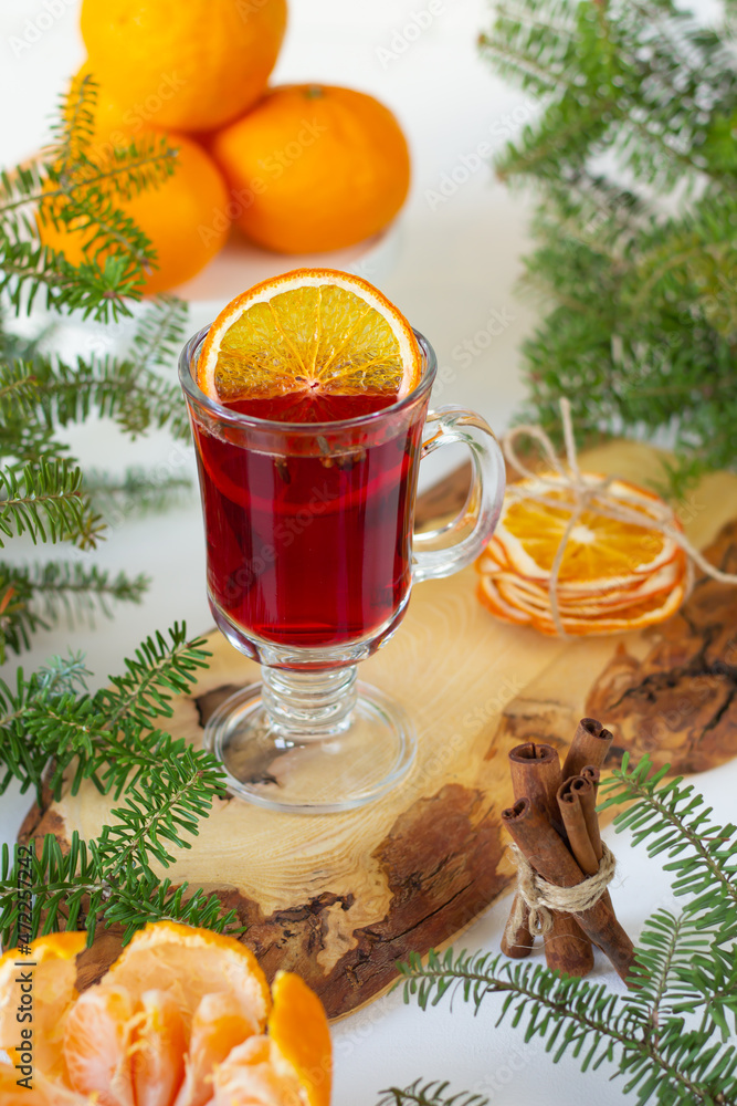 Φωτογραφία Inviting cup of mulled wine placed on a wooden surface, accompanied by peels of orange, fresh citrus fruits, and sprigs of fir, capturing the winter spirit