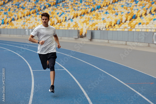 Sportsman running on treadmill on sports stadium