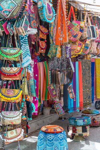 Selling clothes, fabrics and gifts at local street market in holy city Pushkar, Rajasthan, India © OlegD