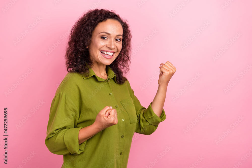 Photo of cheerful positive young afro american woman winner celebrate good mood isolated on pink color background Photo of cheerful positive young afro american woman winner celebrate good mood isolated on pink color background