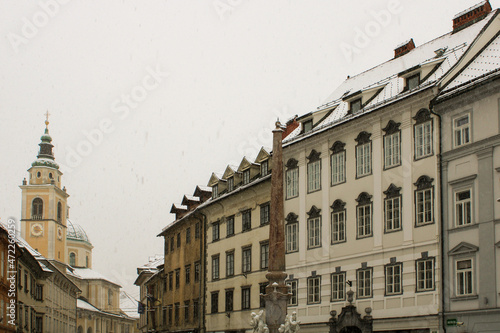 Facciate e tetti innevati di Mestni trg Lubiana con scorcio della fontana dei fiumi carniolani photo