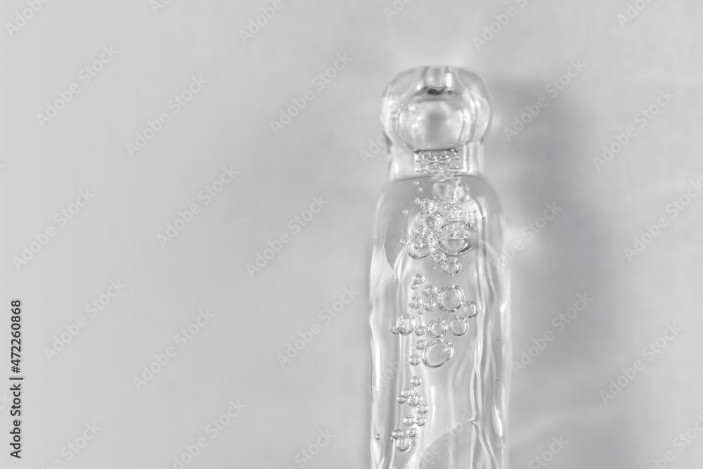 Pipette with fluid hyaluronic acid on blue background. Cosmetics and healthcare concept closeup. Dose of serum or retinol with air bubbles. Flat lay. Luxury gel or beauty product presentation in macro Pipette with fluid hyaluronic acid on blue background. Cosmetics and healthcare concept closeup. Dose of serum or retinol with air bubbles. Flat lay. Luxury gel or beauty product presentation in macro