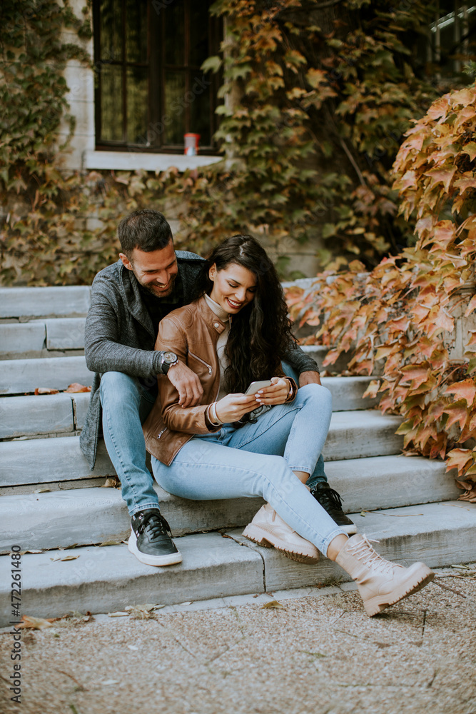 Young couple sitting on outdoor stairs on a autumn day Young couple sitting on outdoor stairs on a autumn day
