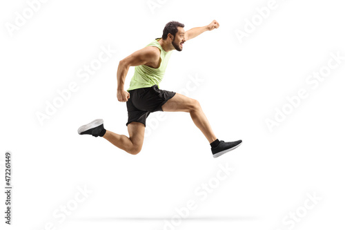 Full length profile shot of a young fit man in sportswear jumping and gesturing happiness