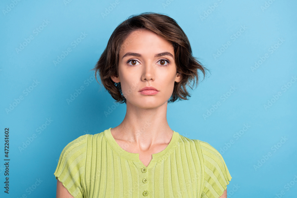 Photo of serious confident young lady wear green t-shirt isolated blue color background Photo of serious confident young lady wear green t-shirt isolated blue color background