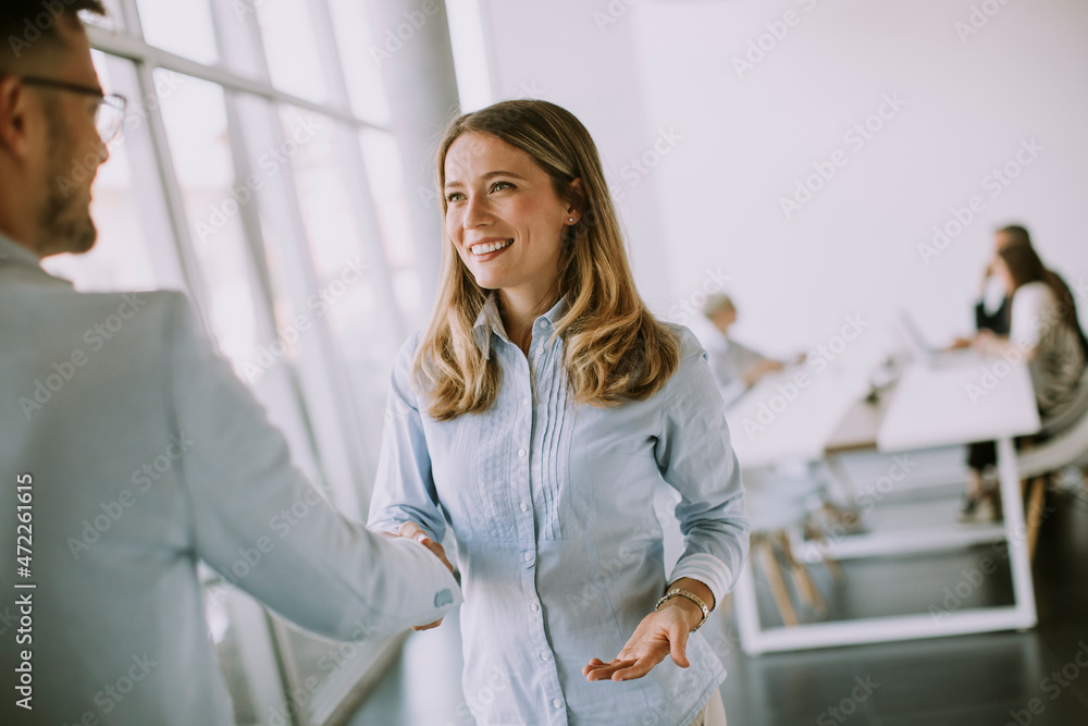Young business couple handshaking in the office Young business couple handshaking in the office