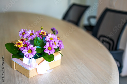 flowers in a box on the desk in the office. a small gift to a colleague