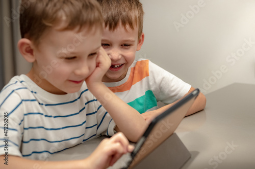 two boys play computer games at home
