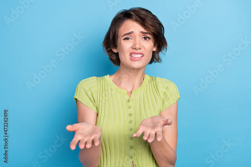 Photo of confused unsure young woman dressed green t-shirt pointing you hands arms isolated blue color background