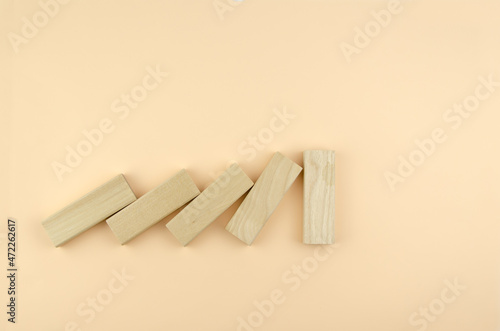 Falling wooden blocks hit the wall. the concept of strength, leadership, resistance,. Wooden cubes fall like dominoes, one block is standing.