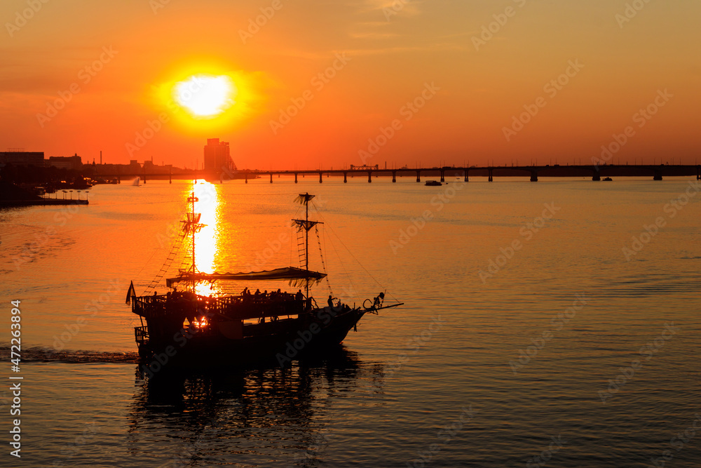 Tourist ship sailing on the Dnieper river at sunset in Dnipro, Ukraine Tourist ship sailing on the Dnieper river at sunset in Dnipro, Ukraine
