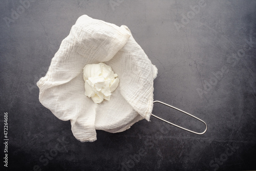 Making Labneh Cheese in a Cheesecloth Lined Strainer: Straining yogurt mixed with lemon juice and salt to make cheese photo