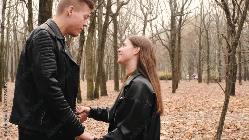 Happy young couple in love walking in autumn park, hugging, kissing and having fun Happy young couple in love walking in autumn park, hugging, kissing and having fun