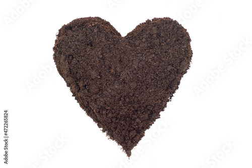 Soil shaped into a heart symbol on white