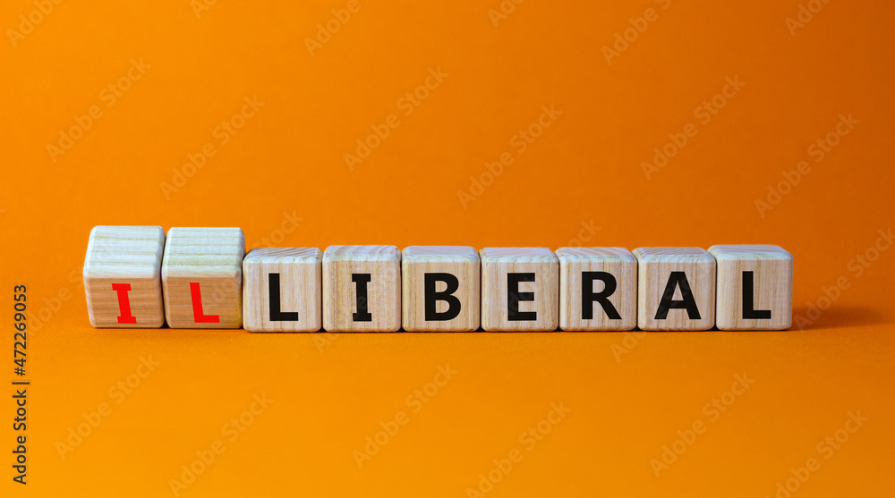 Illiberal or liberal symbol. Turned wooden cubes and changed the word illiberal to liberal. Beautiful orange background. Business, political and illiberal or liberal concept. Copy space. - obrazy, fototapety, plakaty 