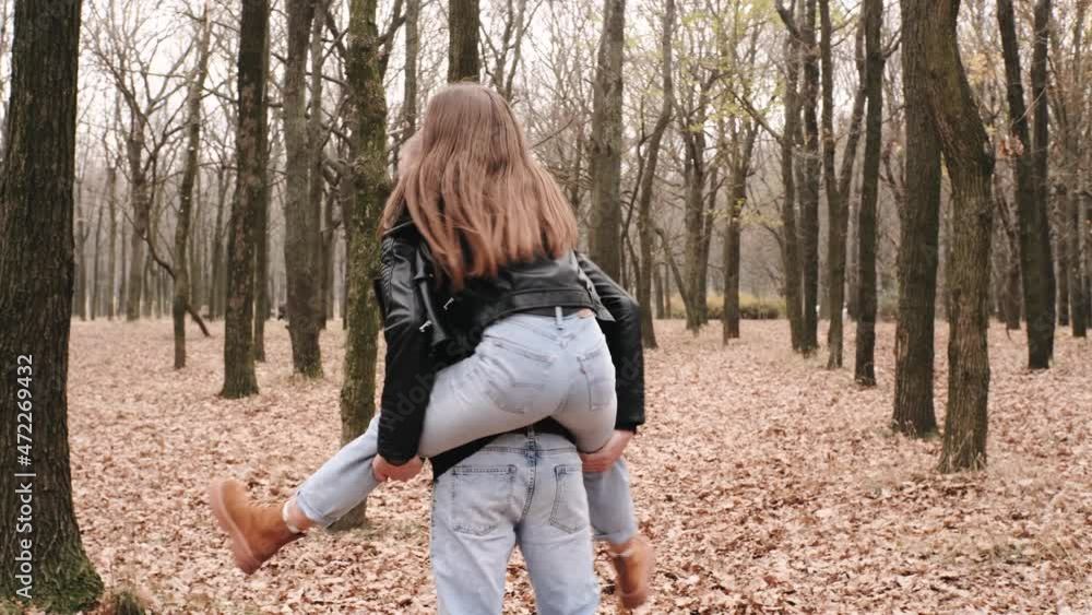 Happy young couple in love walking in autumn park, hugging, kissing and having fun Happy young couple in love walking in autumn park, hugging, kissing and having fun