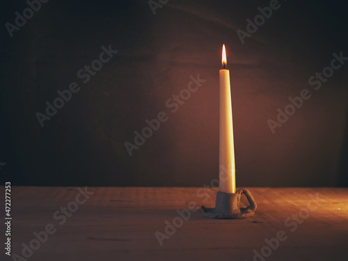 Single tall Vintage style candle in candle holder wide shot  photo