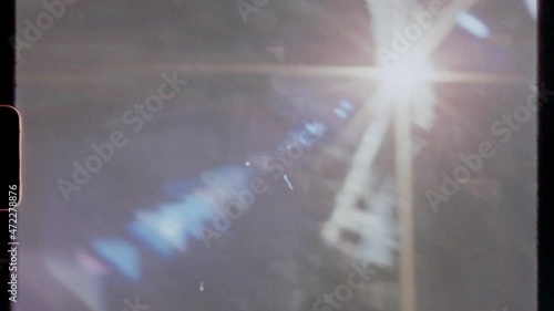 Super 8 frame authentic film scan with sprocket hole and dynamic sun lens flare. Great for overlays for the vintage retro look for digital footage. With authentic camera sound.