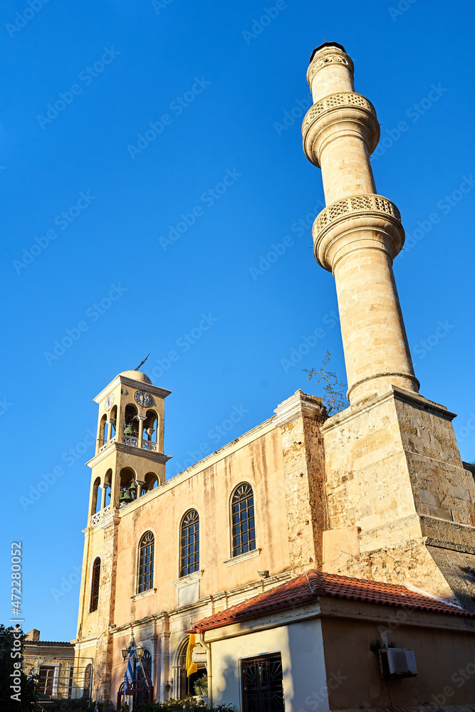 Orthodox church with a bell tower and a minaret in the town of Chania on the island of Crete