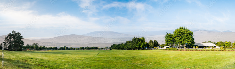 Green grass field and mountain in horizon Green grass field and mountain in horizon