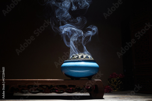 Fotografia Smoke from burning incense sticks standing on lotus incense holder