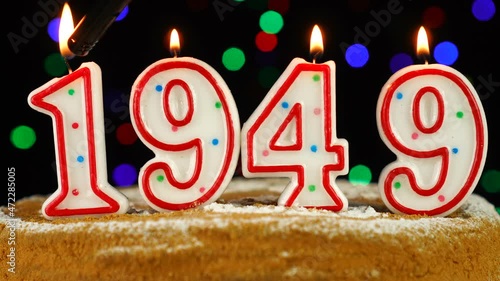 Birthday cake with white burning candles in the form of number 1949 photo