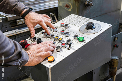 The working grinder switches the regulators on the control panel for switching the grinding modes on the cylindrical grinder.