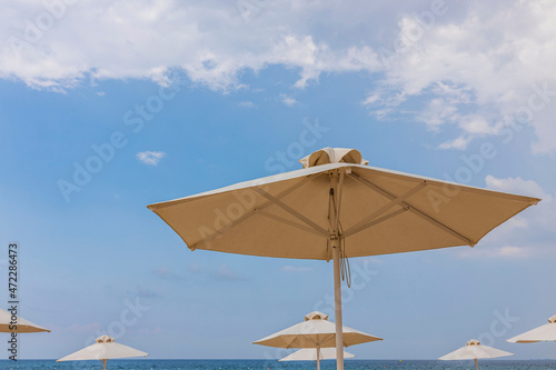  View of white sand beach with sun umbrella and sunbed. Greece.