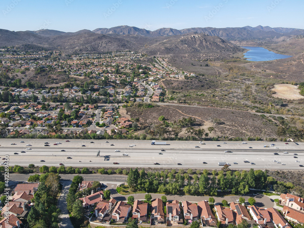 Aerial view of highway with traffic surrounded by houses, Interstate 15 with in vehicle movement. San Diego, California, USA.