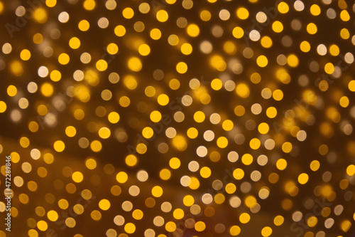 Holiday background of many small yellow bokeh lights