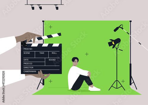 A young male Asian character starring in a drama, a movie set with a chroma key screen, lighting equipment, microphones, and a clapper board