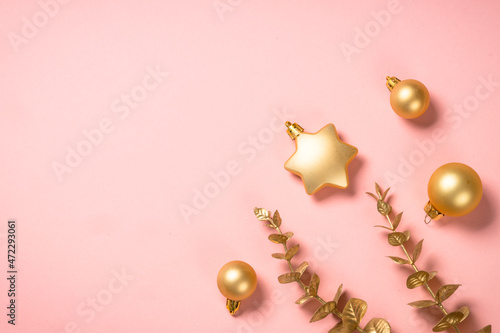 Christmas composition with golden christmas decorations at pink background. Flat lay image with copy space.