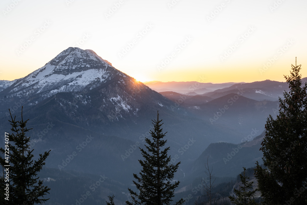 the sun is setting over the Austrian alps