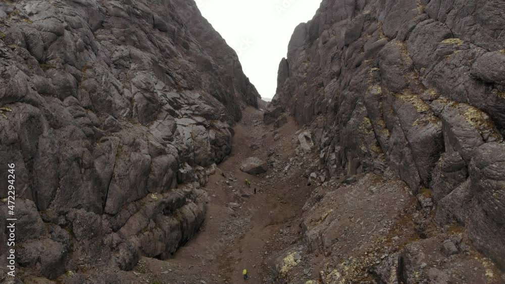 A lonely hiker walks through a mountain gorge. Top view A lonely hiker walks through a mountain gorge. Top view