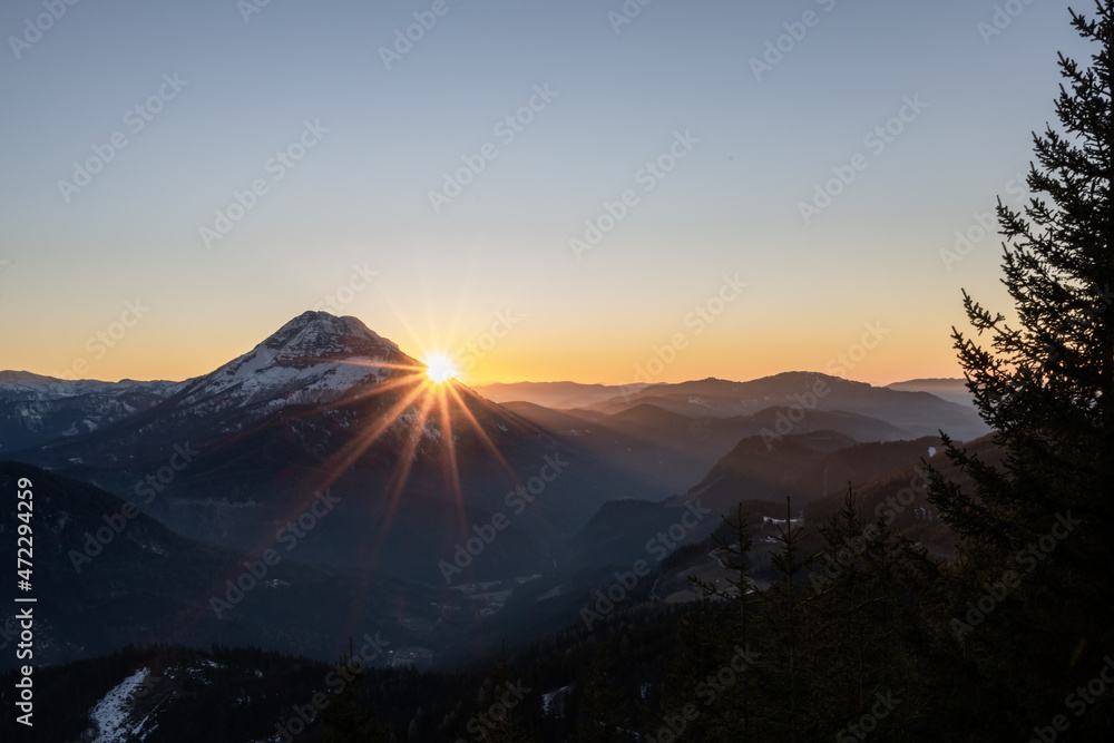 the sun is setting over the Austrian alps